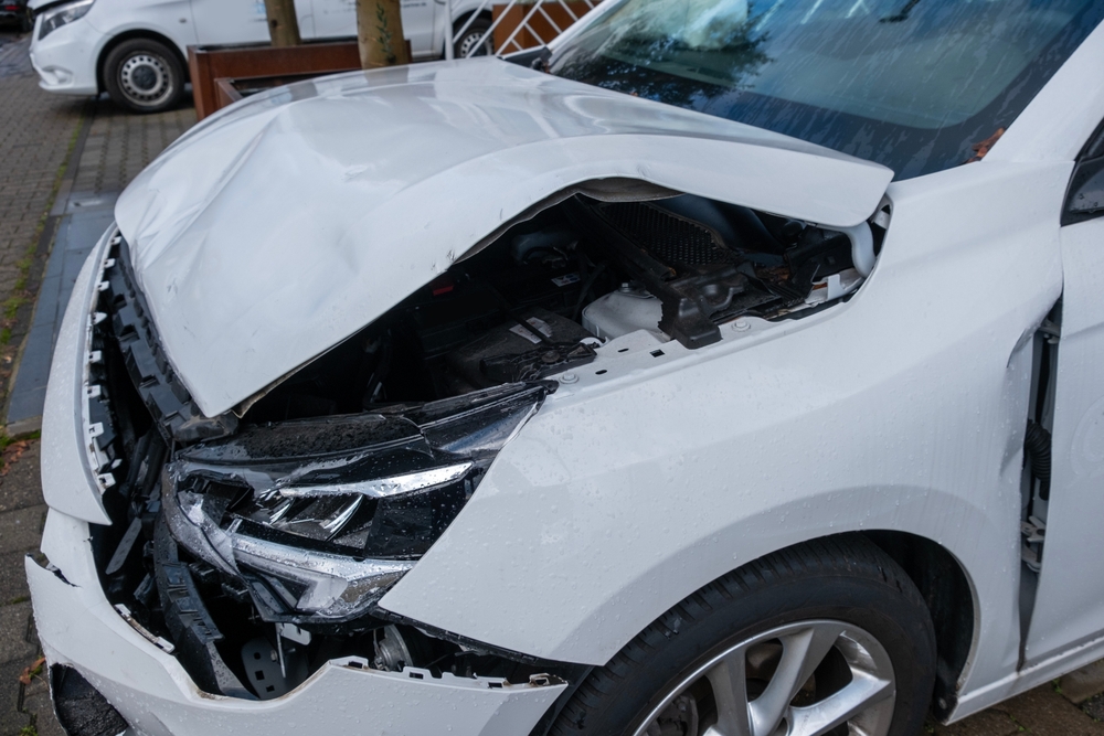 Damaged white car after a crash, illustrating the types of collisions that may lead to an Uber accident lawsuit in New Jersey.