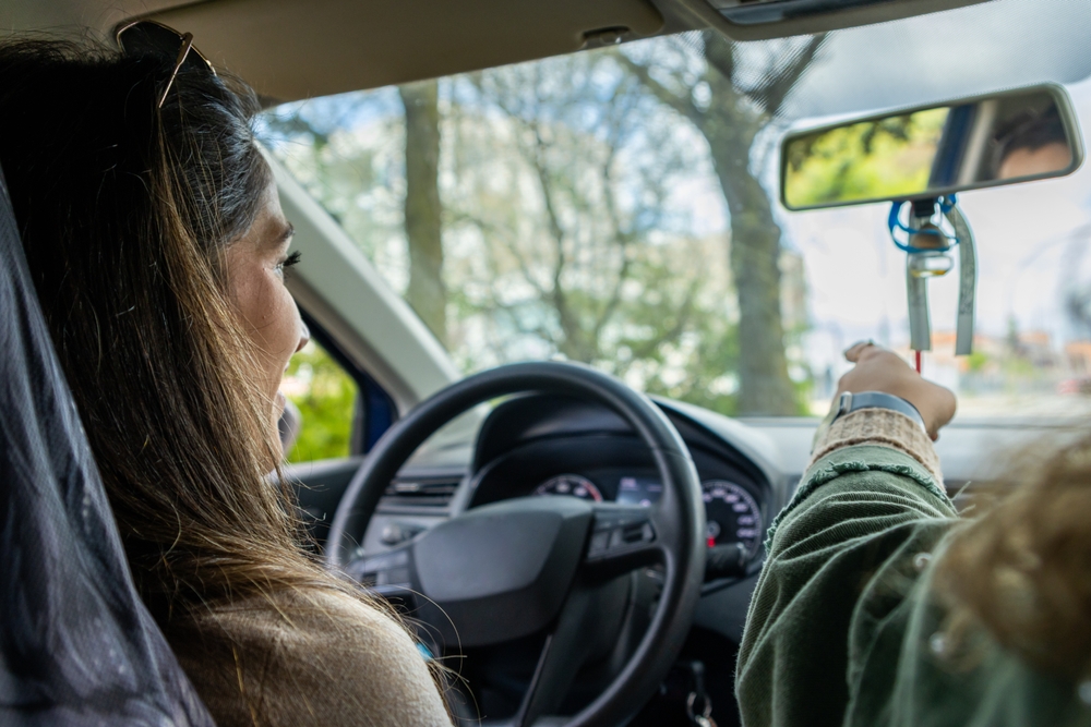 Passenger pointing toward the road while riding in an Uber, illustrating Uber passenger fault concerns
