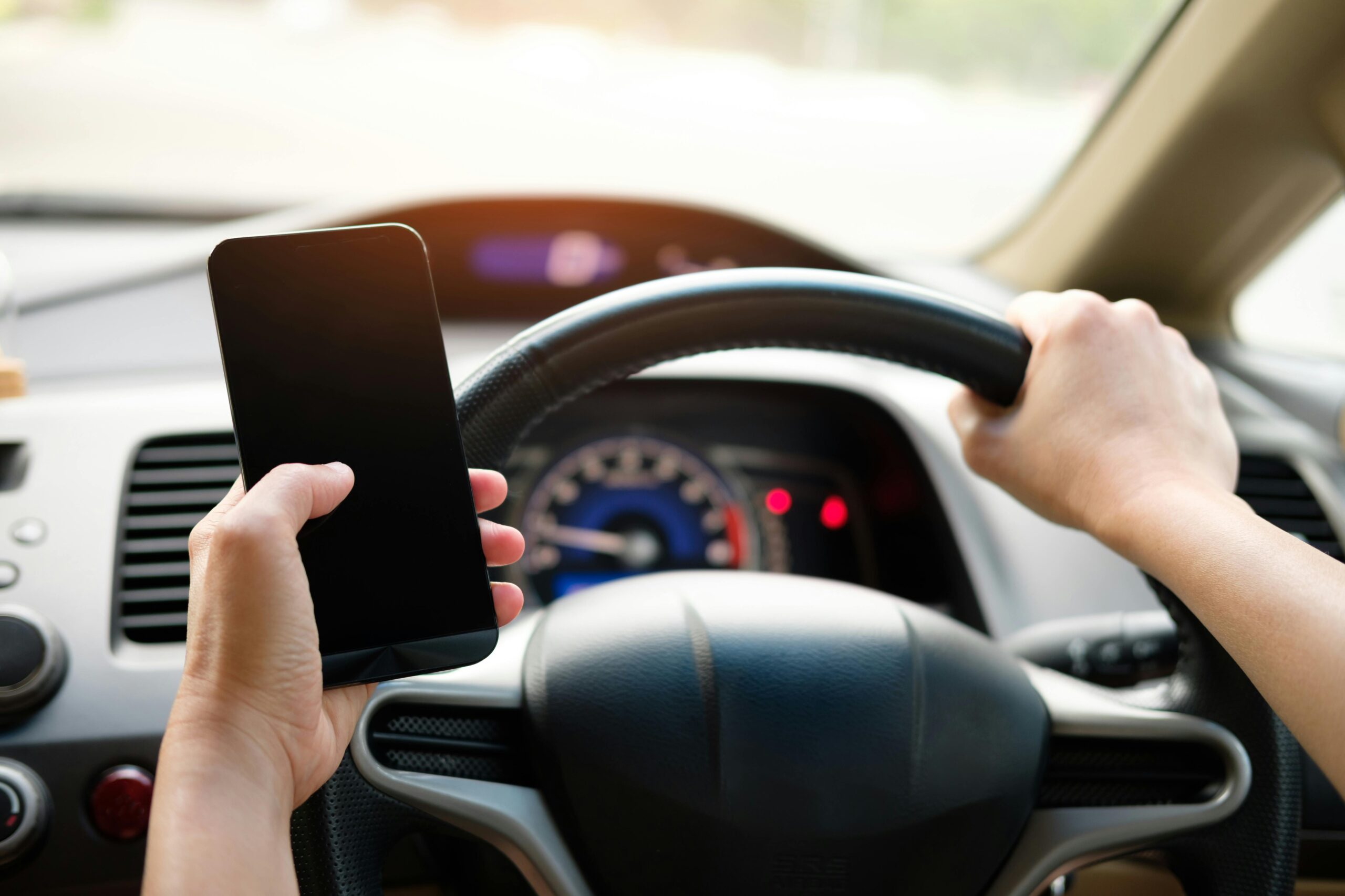 Driver using phone while driving car, distracted driving risk