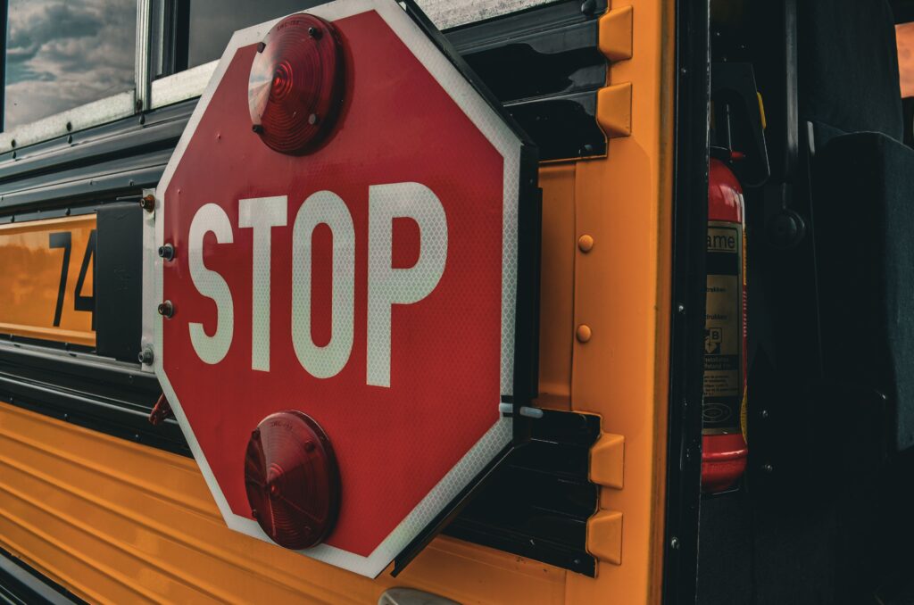 Close-up of a red STOP sign extended from the side of a yellow New Jersey school bus.